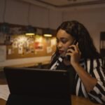 Person on the phone reviewing short term disability for mental health claim paperwork at a desk