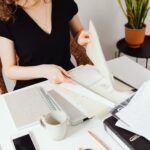 Person on the phone reviewing inpatient mental health treatment cost statements and insurance paperwork at a table